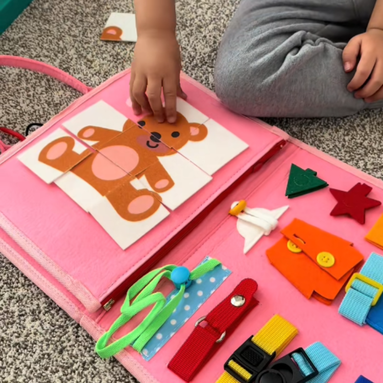 Child playing with a pink educational toy on the floor